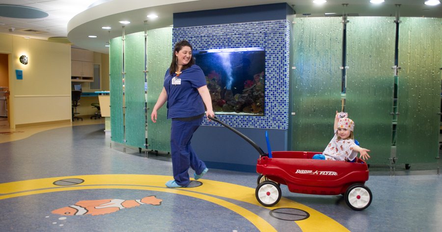 A patient in Don and Lori Watts Pediatric Center is taken to surgery in a wagon to make the experience a little less stressful. The wagon, as well as a big wheel for patients, was paid for through the Kadlec Foundation. (Courtesy Kadlec Foundation)