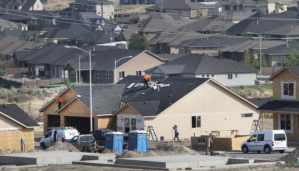 Workers finish roofing on homes in south Richland. The Tri-City area’s population continues to increase, growing 1.7 percent over last year. (Photo: Paul T. Erickson)