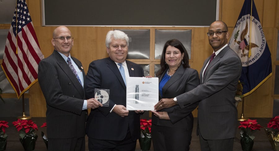 Michael Johnson, NRC Deputy Executive Director for Operations (right), and Vonna Ordaz, Acting Director of the NRC Office of New Reactors (second from right) receive NuScale's application to certify the company's small modular reactor design from NuScale Chief Nuclear Officer Dale Atkinson (second from left) and NuScale Vice President for Regulatory Affairs Tom Bergman (left). (Courtesy Nuclear Regulatory Commission)