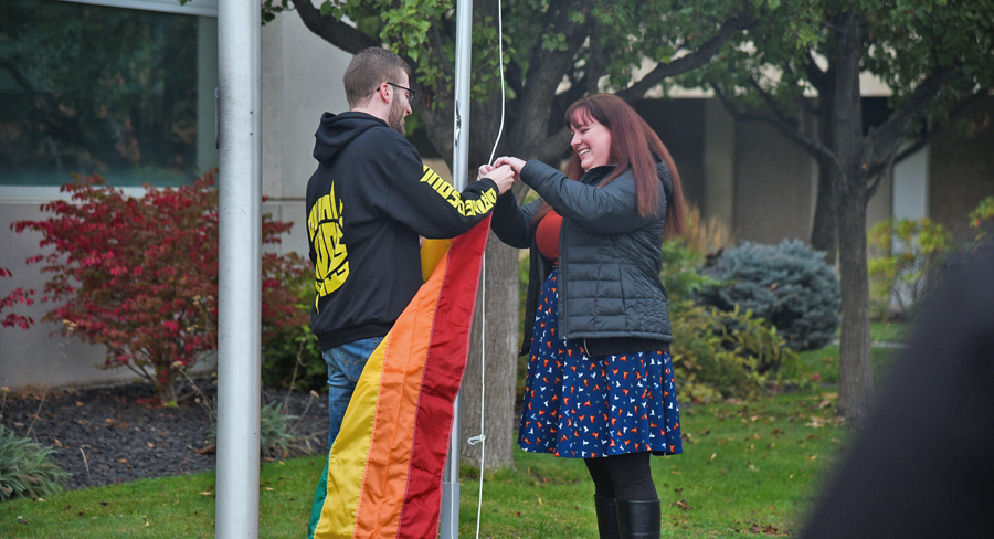 Katie Banks, professor of political science at Washington State University Tri-Cities, and Zachary Harper, president of the Associated Students of WSU Tri-Cities, raise the pride flag at the Richland campus in October. The branch campus’ Office of Student Affairs partnered with the Associated Students group for the pride flag-raising ceremony to kick off a series of events in recognition of “Outober,” an event which aims to raise awareness of issues related to lesbian, gay, bisexual, transsexual, queer and other underrepresented communities. (Courtesy WSU Tri-Cities)