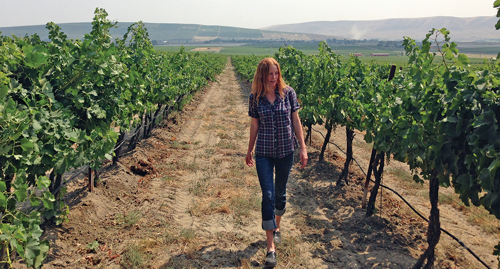 Sarah Hedges Goedhart, head winemaker for Hedges Cellars on Red Mountain, walks through their organically farmed estate vineyard. (Photo by Andy Perdue)