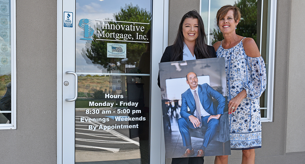 Karla Melior and her daughter Kayleen hold a photograph of the late Dan Melior outside Innovative Mortgage. Dan’s family and his Kennewick team plan to carry on Dan’s legacy at the mortgage broker business. (Photo by Elsie Puig)

