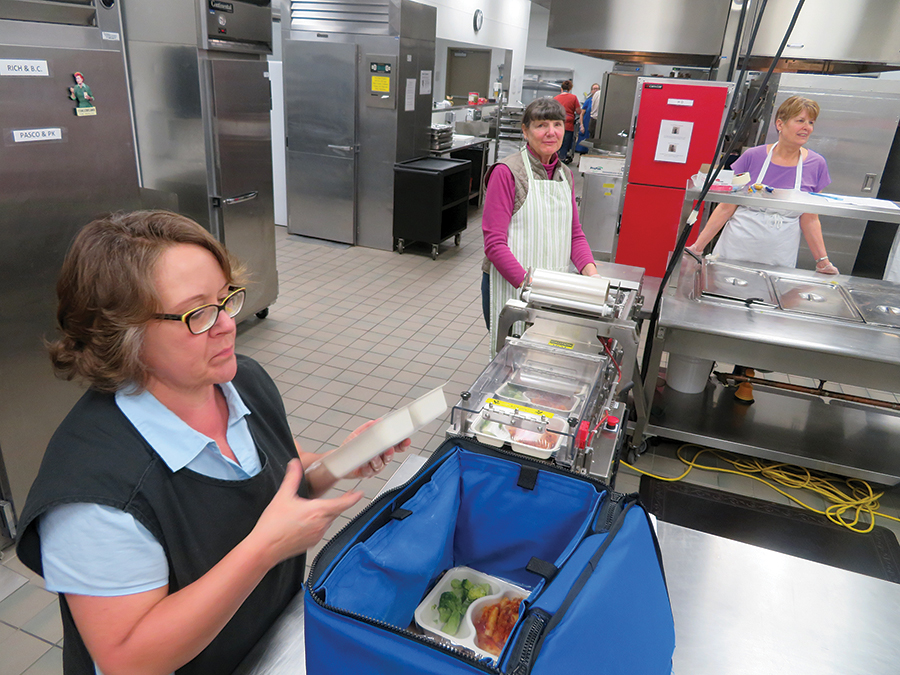 Mid-Columbia Meals on Wheels is canceling its annual fundraising breakfast scheduled for March 10 amid concerns about the continued statewide spread of coronavirus. Stephanie Burke, the packaging coordinator for Meals on Wheels, slides a pasta meal into an insulated tote to ready it for delivery. (File photo)