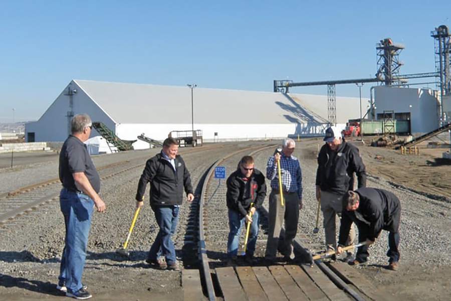 Officials with Central Washington Corn Processors pound in ceremonial rail spikes to celebrate the opening of their multimillion-dollar facility in this November 2016 file photo. The company is expanding its Richland footprint again this year. (File photo)
