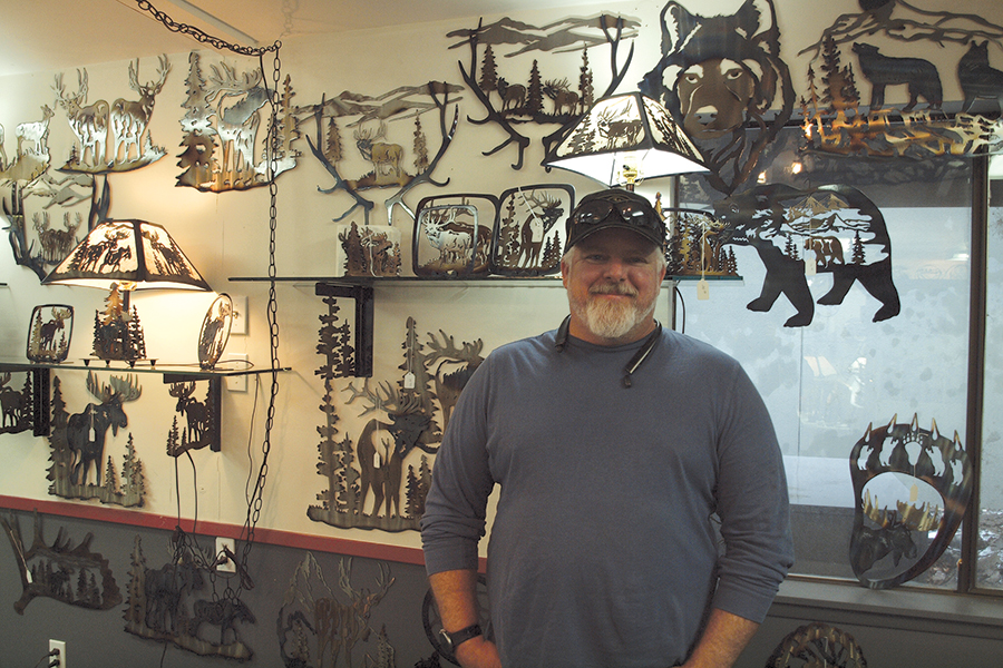 Pat Knight stands flanked by a sampling of the metal art creations for sale at his 4432 W. Clearwater Ave. shop in Kennewick. All of the pieces are designed, fabricated and finished by Knight, his brother Randy, and their father, Larry. (Photo by Laura Kostad)