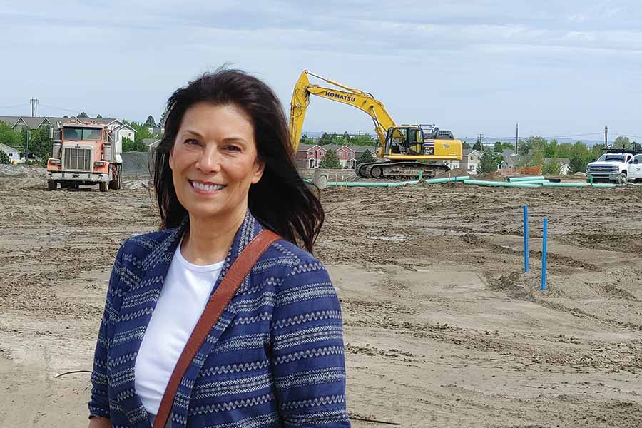Carmen Villarma stands at the site she and her husband, Dennis Pavlina, are developing, The Resort at Hansen Park, a $50 million mixed-use development that will bring three types of rental homes and new commercial space to the Columbia Center Boulevard corridor. Site work began in early 2021. The first homes will be available for rent by late 2021. (Photo by Wendy Culverwell )