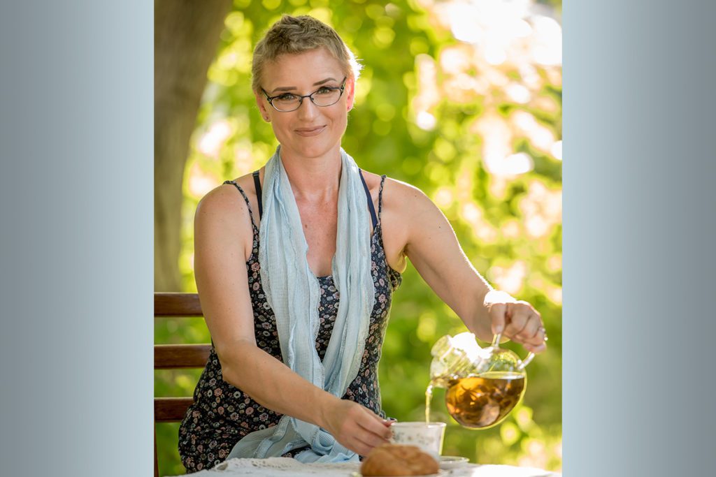 Libby Boothe of Kennewick pours tea during a photo shoot for a Warrior Sisterhood calendar in this 2017 photo. The tea party photo is a nod to the annual Witches’ Tea Party she held every October in conjunction with her birthday, a tradition she kept up even while fighting Stage 4 breast cancer. She died July 23 at age 44. (Courtesy Scott Butner Photography)