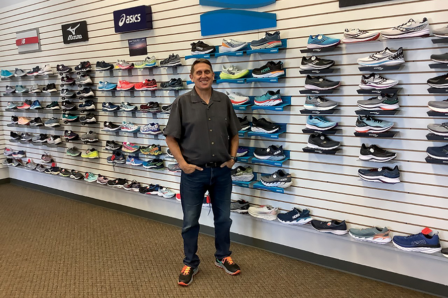 Owner Scott Conrad stands in front of his shoe inventory at Runners Soul at 5020 W. Clearwater Ave. in Kennewick. (Photo by Jeff Morrow)