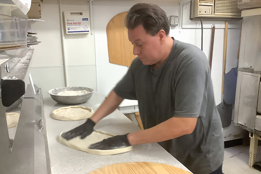 Merced Flores-Garcia prepares pizza dough at his restaurant, Mercy’s Pizza Taco, 524 N. Third Ave., across the street from City Hall. (Photo by Jeff Morrow)