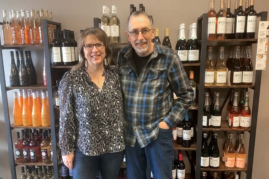 Marlys and Charles Aspinwall stand in front of their shelves of non-alcoholic wines and spirits. The couple, who own Kindred Spirits Alcohol Free Bottle Shop and Sober Bar, opened a store at 430 George Washington Way, Suite 103. (Photo by Jeff Morrow)