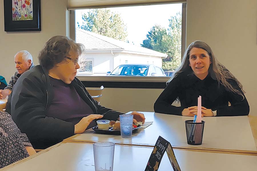 Kristi Thien, nutrition services director for Mid-Columbia Meals on Wheels, visits with diners at the nonprofit’s Richland cafe shortly before she retired in early February. (Photo by Wendy Culverwell)