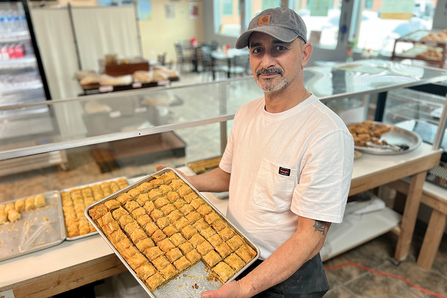 Adnan Al Hayyawi holds a tray of pistachio baklava in his Somer Bakery at 5601 W. Clearwater Ave., Suite 111, in Kennewick. The bakery offers a taste of home for Al Hayyawi. (Photo by Sara Schilling)