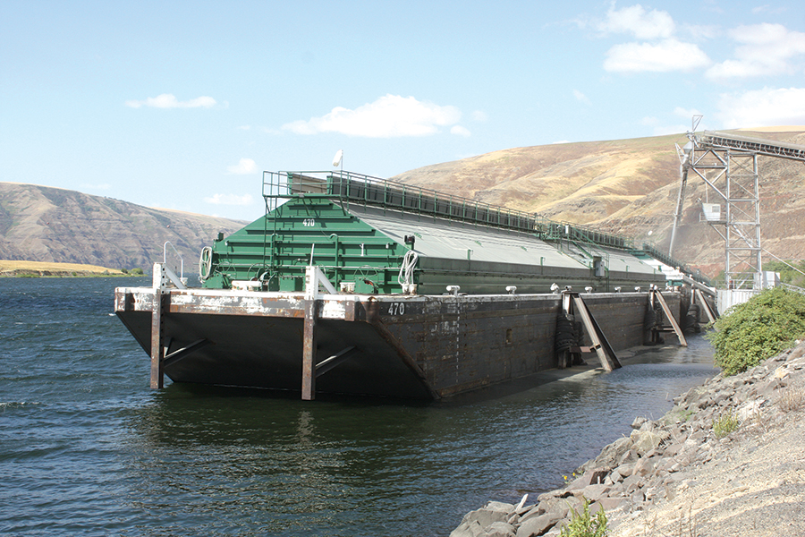 Workers load wheat onto a barge on the Snake River. (Courtesy Washington Association of Wheat Growers)
